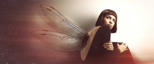 Delicate, feminine fragility. Young woman with wings. Conceptual and artistic image of a young girl with insect wings. Magical atmosphere like in a dream. The young woman is curled up looking behind her. She protects her in a crouching position. Delicacy, protection, fragility and violence against woman concept.