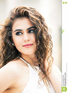 Beautiful woman with curly hair. Makeup A beautiful and happy young woman. Portrait of a girl with curly hair. side look. Makeup on her face, perfect style. Sensuality, freshness, beauty and emotions.