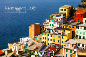 Colorful dwellings and Mediterranean Sea. Italian buildings in the village Riomaggiore, Cinque Terre National Park, Italy.