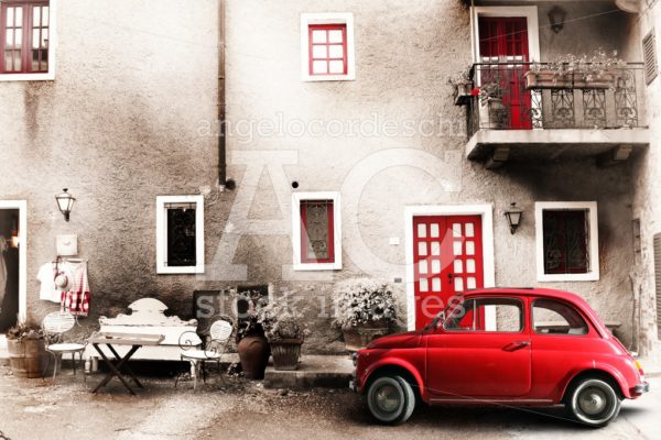 An Old Italian House With A Small Subcompact Old Red Car. Vintag Angelo Cordeschi