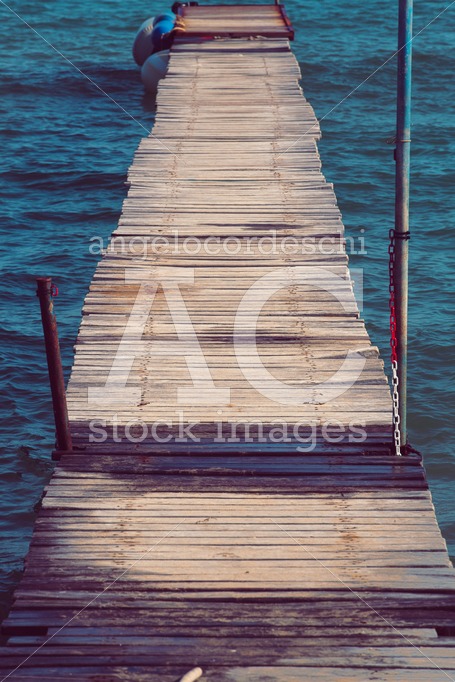 Antique Wooden Boardwalk Over Blue And Azure Sea. Small Waves Wi Angelo Cordeschi
