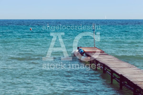 Antique Wooden Boardwalk Over Blue And Azure Sea. Small Waves Wi Angelo Cordeschi