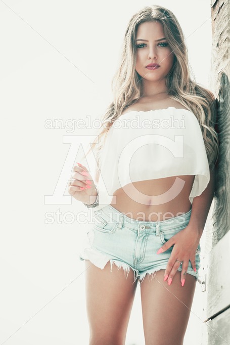 Beautiful Blonde Girl, Long Hair And Blue Eyes, Shorts And White Angelo Cordeschi