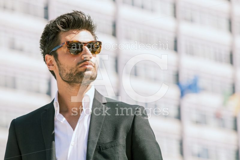 Confident business handsome man with sunglasses standing outdoor. - Angelo Cordeschi