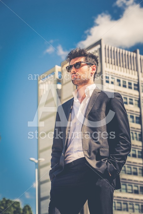 Confident business handsome man with sunglasses standing outdoor. - Angelo Cordeschi