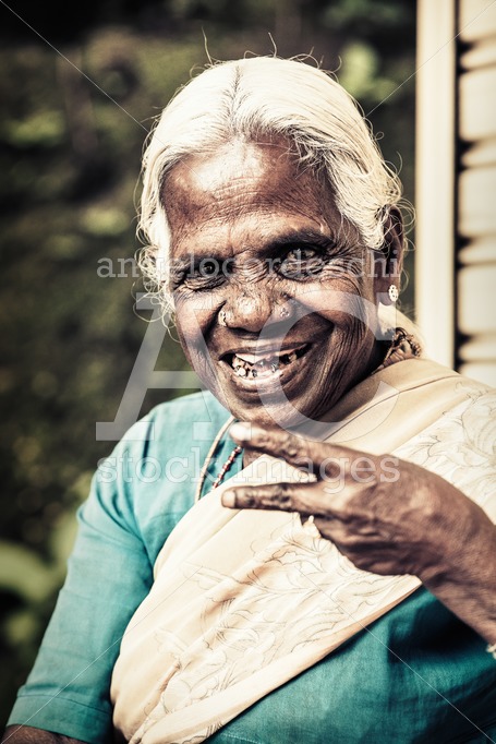 Elderly Sri Lankan woman smiling happy making peace sign. - Angelo Cordeschi
