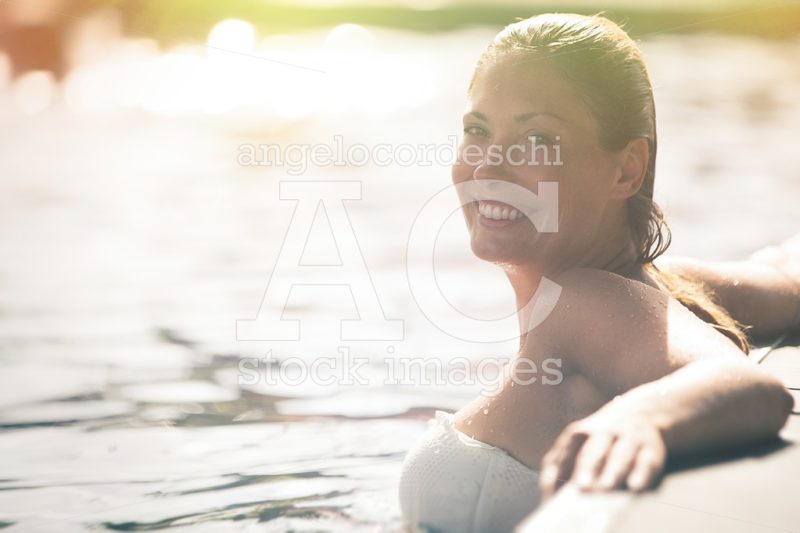 Enjoy the summer. Woman relaxing in the pool water. A beautiful - Angelo Cordeschi