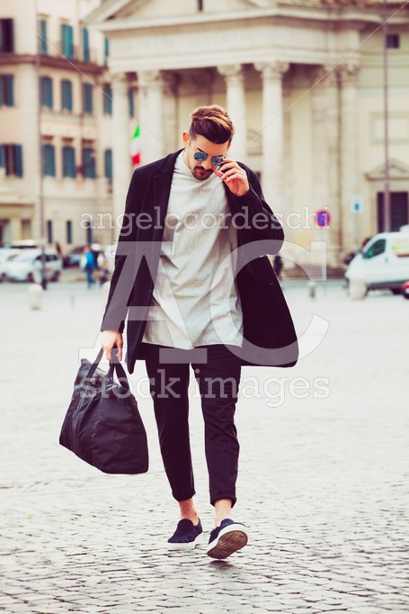 Fashionable Young Man Walking In The Street In The City. With Su Angelo Cordeschi