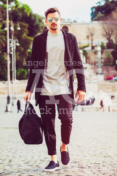 Fashionable Young Man With Holdall Bag Walking In The Street In Angelo Cordeschi