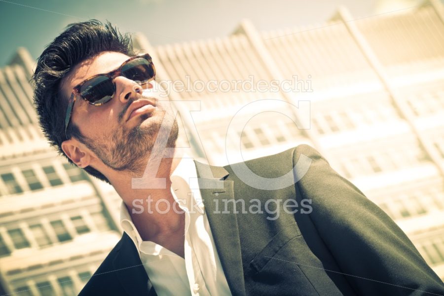 Handsome businessman with sunglasses, outdoor in the city. Charming and modern style. - Angelo Cordeschi