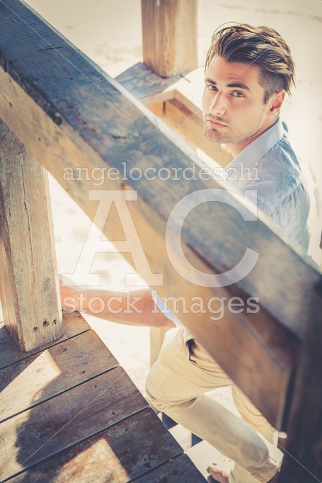 Handsome Guy With Trendy Hairstyle Going Down On Wooden Stairs W Angelo Cordeschi