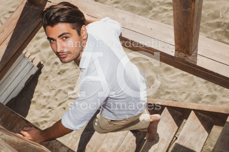 Handsome Positive Guy With Trendy Hairstyle Going Down On Wooden Angelo Cordeschi