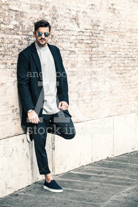 Handsome Stylish Man Leaning On A Wall With Sunglasses And Moder Angelo Cordeschi