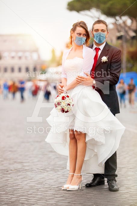 Newly married couple with face mask on their wedding day. On the - Angelo Cordeschi