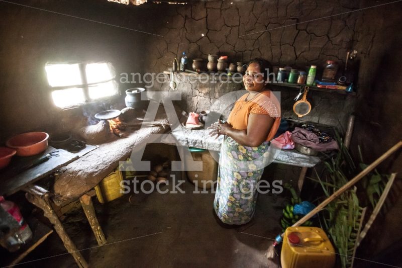 Smiling Sri Lankan woman inside her modest home. Rural kitchen. - Angelo Cordeschi