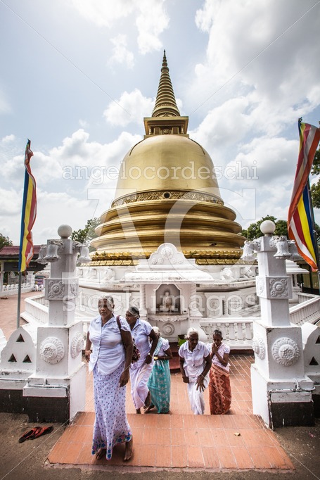 Sri Lankan women praying in front the Golden Temple in Dambulla - Angelo Cordeschi