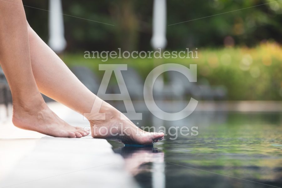 Summer Vacation In The Pool In A Resort. Woman Legs Sitting And Angelo Cordeschi