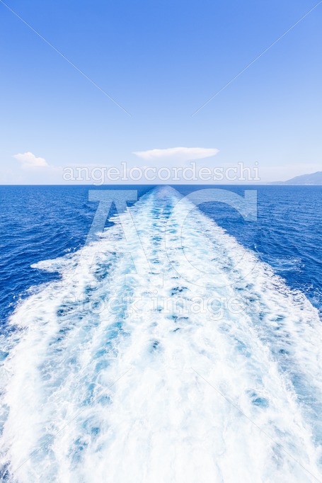 Wake Of Water From A Boat, Open Sea With Horizon And Blue Sky. W Angelo Cordeschi