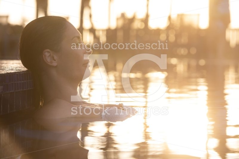 Woman Relaxing By The Pool At Sunset. Intense Warm Lights. Beaut Angelo Cordeschi