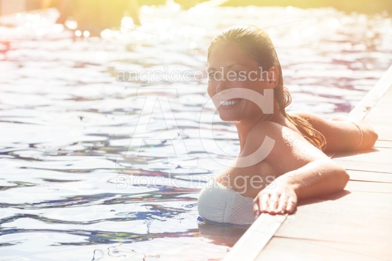 Woman relaxing in the pool water. A beautiful woman with big smi - Angelo Cordeschi