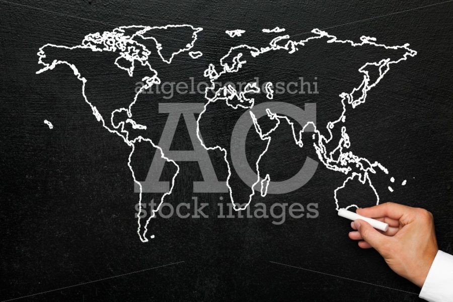 World map on blackboard. A hand draws a stylized globe map of th - Angelo Cordeschi