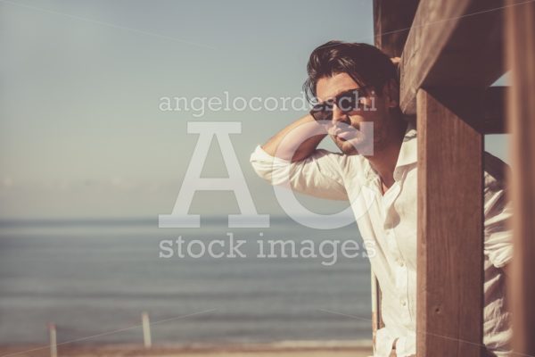 Young Attractive Man With Sunglasses On The Beach Looking Outdoo Angelo Cordeschi