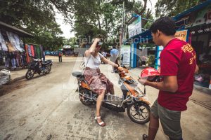 Tourist woman riding a moped with a man who rents scooters. - Angelo Cordeschi